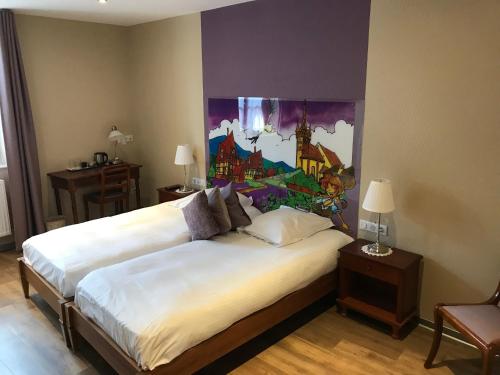 - une chambre avec 2 lits et un tableau mural dans l'établissement Auberge Le Meisenberg, à Châtenois