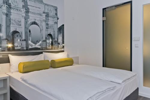 a bedroom with a white bed with a yellow pillow at Super 8 by Wyndham Munich City West in Munich