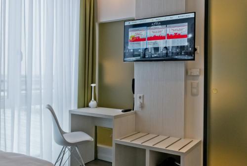 a room with a tv and a bed and a chair at Super 8 by Wyndham Munich City West in Munich