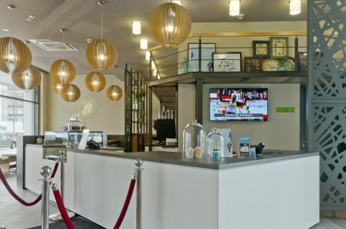 a bar in a restaurant with a tv on the wall at Super 8 by Wyndham Munich City West in Munich