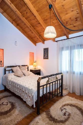 a bedroom with a bed and a wooden ceiling at Samarian Cottage in Lákkoi
