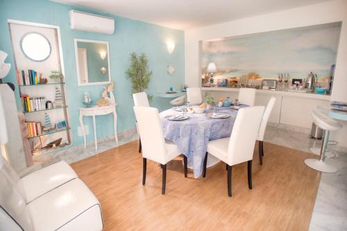 a dining room with a table and white chairs at Bed & Breakfast Venezia in Marina di Carrara