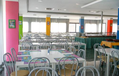 a dining room with tables and chairs and pink walls at Hotel Elba in Rimini