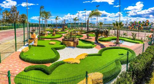a miniature golf course in a park with a horse and grass at Devesa Gardens in El Saler