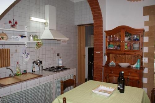cocina con mesa, fregadero y fogones en Aura Maris, en Castellammare del Golfo