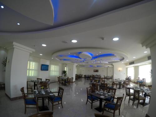 a dining room with tables and chairs and blue ceilings at Rehana Plaza Hotel in Cairo