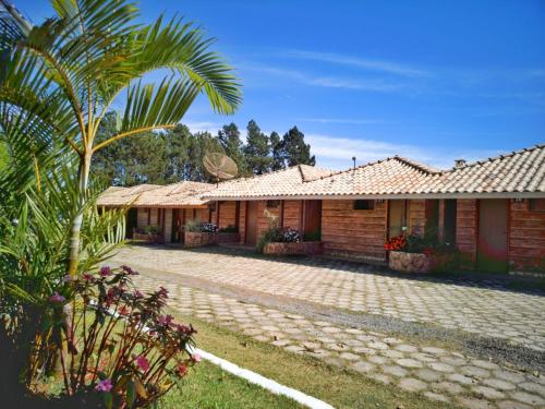 a house with a palm tree in front of it at Fazenda Morro Pelado in Águas de Lindóia