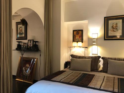 une chambre avec un lit avec un tableau sur le mur dans l'établissement Le Marais Maison En Ville, à Paris