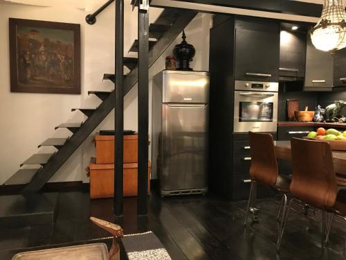 une cuisine avec un escalier et une table avec des chaises dans l'établissement Le Marais Maison En Ville, à Paris