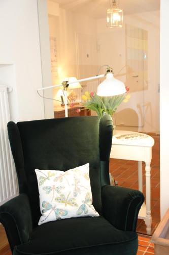 a green chair with a pillow next to a table at The Little Guesthouse in Salzburg