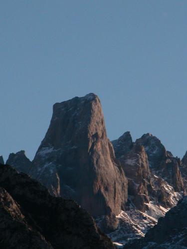 a rocky mountain with snow on top of it at Hotel Torrecerredo in Arenas de Cabrales