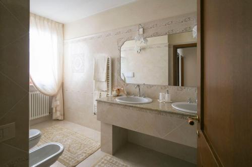 a bathroom with two sinks and a mirror and a toilet at La Casa di Pimpi in Desenzano del Garda