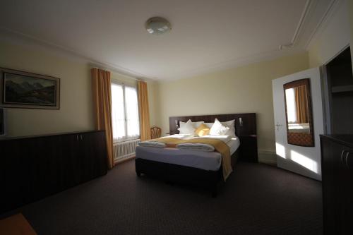 a hotel room with a bed and two windows at Gasthaus zum Kreuz in Luzern