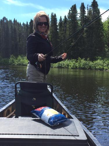 a woman in a boat holding a fishing pole at Bed and Breakfast Du Repos in Saint Quentin