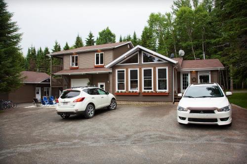 two cars parked in a parking lot in front of a house at Bed and Breakfast Du Repos in Saint Quentin