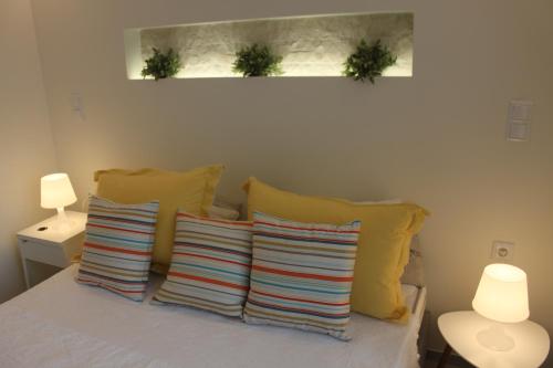 a group of pillows on a bed with two plants at Meli Seaside Villas in Khránoi