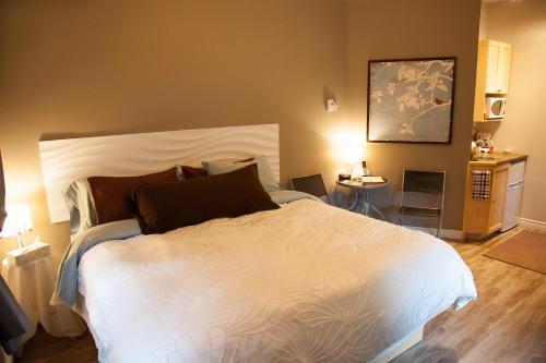 a bedroom with a large white bed and a table at Bed and Breakfast Du Repos in Saint Quentin