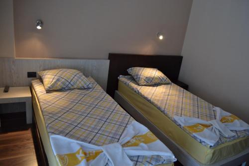 two beds sitting next to each other in a room at Venec Hotel in Debar