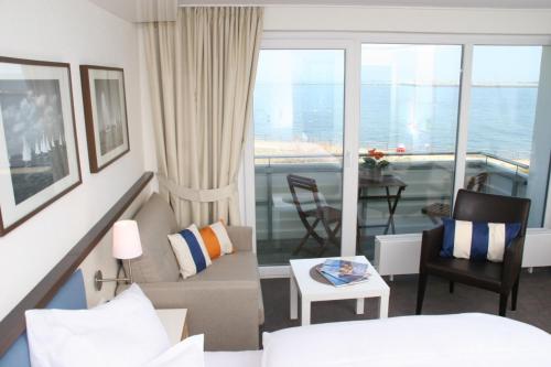 a living room with a couch and a room with a balcony at Miramar in Helgoland