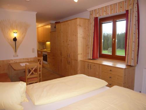 Schlafzimmer mit einem Bett, einem Schreibtisch und einem Fenster in der Unterkunft Ferienhof Grossgrub in Vorderstoder