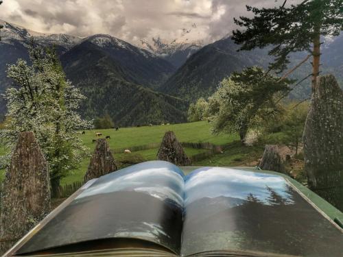 an open book with a view of a mountain at Heshkili huts and cabins Svaneti in Keshkili