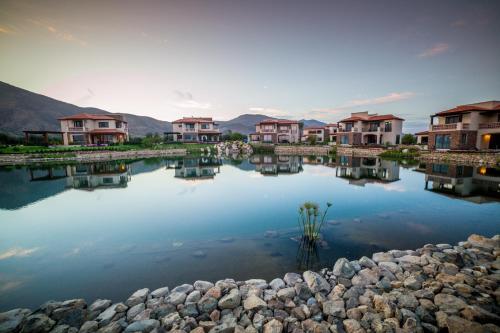 a row of houses on a lake with houses at El Cielo Resort in Valle de Guadalupe