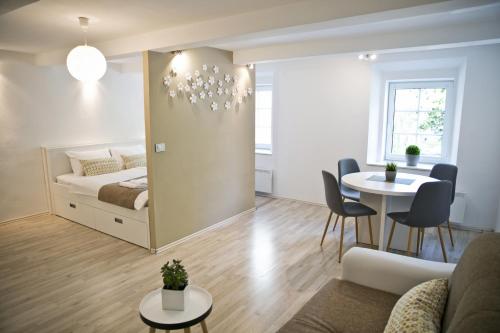 a living room with a bed and a table at Apartments Hiša Pod Gradom in Ljubljana