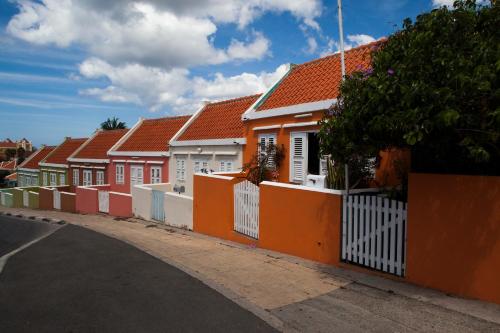 a row of houses on a street with a fence at Boutique Hotel 't Klooster in Willemstad