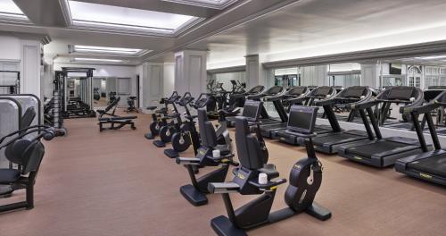 a gym with rows of treadmills and elliptical machines at Hotel Crescent Court in Dallas