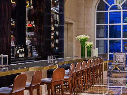 a bar with a row of chairs in a restaurant at Hotel Crescent Court in Dallas