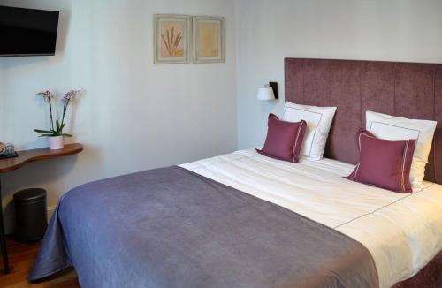 a bedroom with a large bed with purple pillows at Notarishuis Beveren B&B in Beveren
