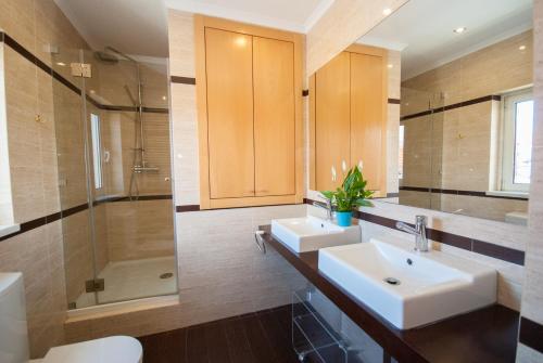 a bathroom with two sinks and a shower at Binny's House Cascais - Renting rooms not the whole house in Alcabideche