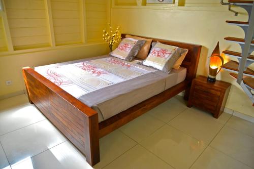 a bed with two pillows on it in a room at Résidence Kay Mamy Zèt in Le François