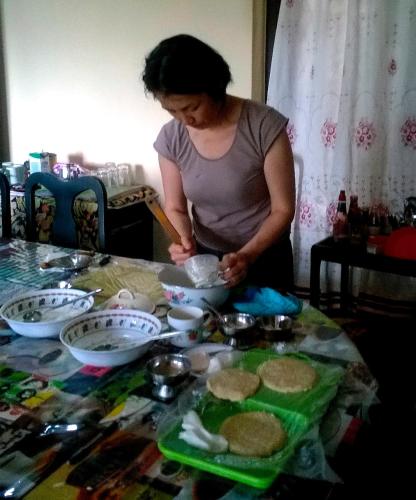 a woman standing at a table making cookies at Evergreen in Kandy