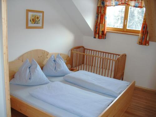 a bedroom with a bed with white sheets and a window at Ferienhof Grossgrub in Vorderstoder