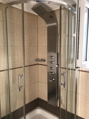 a shower with a glass door in a bathroom at Stampalia Luxury Studios in Astypalaia Town