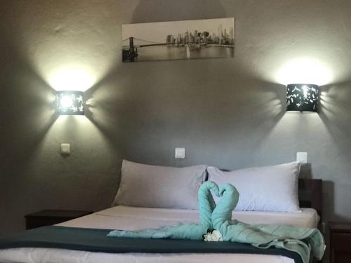 uma cama com um bicho de peluche azul em cima em L'ESCALE em Nosy-Be