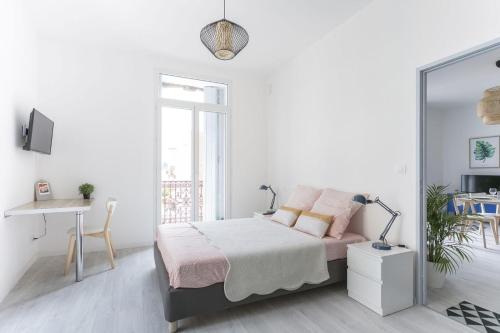 a white bedroom with a bed and a mirror at Sunny Relaxing Apartement in Béziers