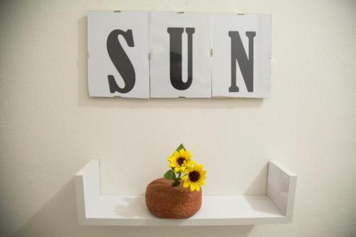 a vase with a sunflower sitting on a shelf at By the Sea in Terrasini