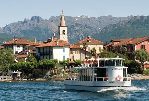 un barco en el agua frente a una ciudad en Villa Toscanini, en Stresa