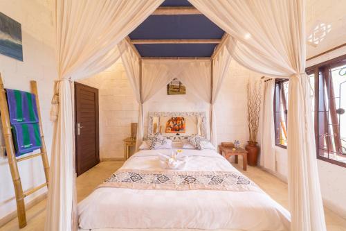 a bedroom with a large white bed with curtains at Padang Padang Breeze in Uluwatu