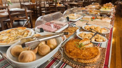 einen Tisch mit vielen verschiedenen Arten von Lebensmitteln in der Unterkunft Hotel Princesa dos Vales in Veranópolis