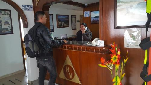 a man and a woman standing at a cash register at Hotel Venecia Confort in Pasto