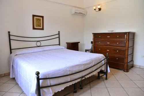 チステルニーノにあるIl Trullo delle Rondiniのベッドルーム1室(ベッド1台、ドレッサー付)