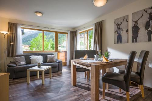 ein Wohnzimmer mit einem Tisch und einem Sofa in der Unterkunft Appartements Fortuna in Pertisau