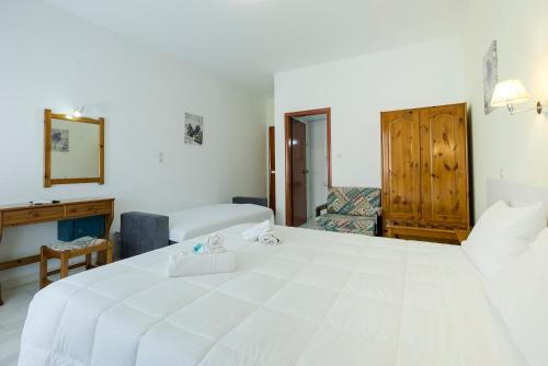 a bedroom with a large white bed in a room at Revekka Rooms in Kissamos