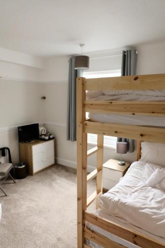 - une chambre avec des lits superposés et un bureau dans l'établissement Longstone House Bed & Breakfast, à Seahouses