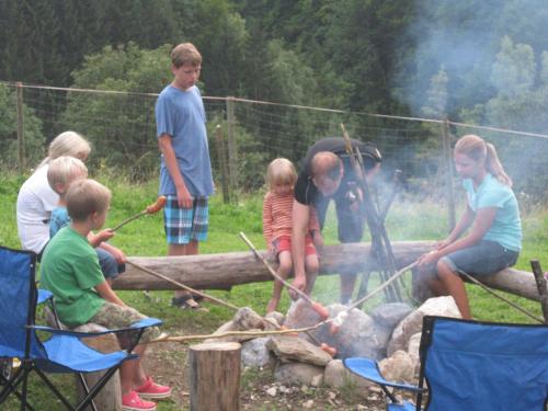 a group of children standing around a camp fire at Landhaus Seebacher in Spital am Pyhrn