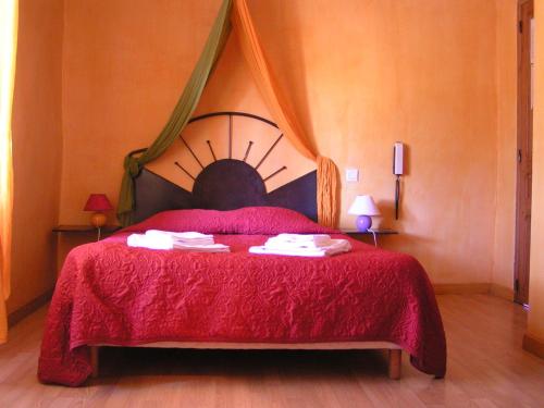 サラヴァにあるHotel Des Sitesのベッドルーム1室(赤いベッドカバー付)