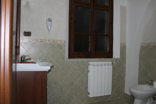 a bathroom with a sink and a toilet and a window at B&B Il Laghetto in Serra San Bruno